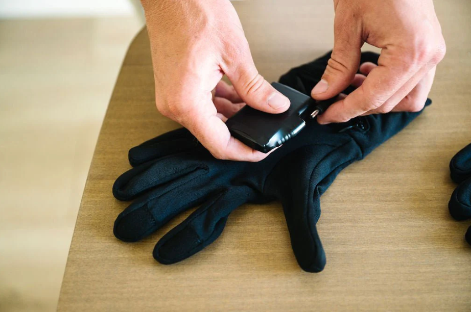 Demonstrating how to plug the 7V rechargeable battery into Toasty Touch heated gloves